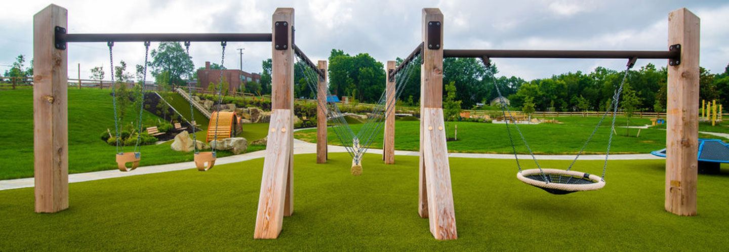 The swings and spinner area features toddler bucket swings, a nest swing, a rope swing and a spinner.